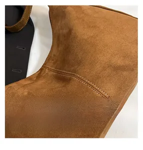 Dettaglio macro delle doppie cuciture bianche su una borsa tote in pelle scamosciata