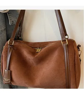 Detail of brown suede Boston bag featuring soft matte texture and gold metal zipper
