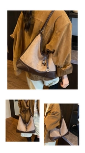 Detail van contraststiksels op de bruine suède en lederen vintage tote schoudertas