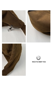 Macro view of dark brown canvas dumpling bag showing smooth silver zipper and stitching