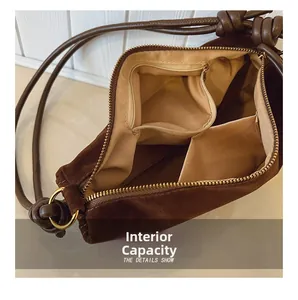 Internal view of brown suede crossbody bag showing main compartment and inner pockets