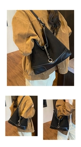 Detail van zwarte matte leren shopper met witte contraststiksels en metalen ringgesp