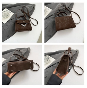 Detail view of dark brown suede handbag with silver hardware and bottom metal studs