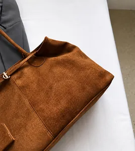 Detail van de karamelkleurige suède textuur en het zachte materiaal van de draagtas