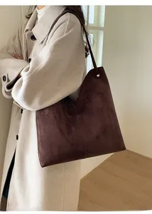 Detail der mokkafarbenen Wildleder-Einkaufstasche mit minimalistischer Naht am Model