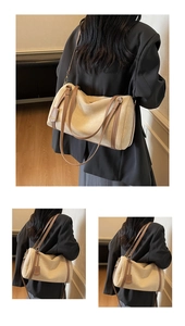 Detail of beige faux suede Boston bag with brown leather straps and metal buckle