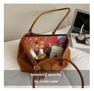 Vue macro du sac cabas en daim marron montrant une grande capacité intérieure quotidienne