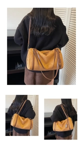 Detail of suede Boston bag in brown with leather straps and zip closure for women