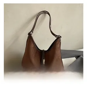 Detailed view of the brown suede hobo bag featuring contrast leather trim and a metal buckle