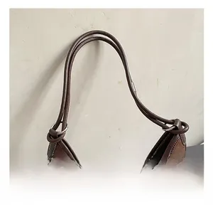 Detail of soft suede tote bag with reinforced handles and durable metal hardware