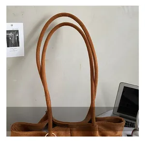 Détail des anneaux dorés et des poignées en daim doux sur le sac à bandoulière vintage
