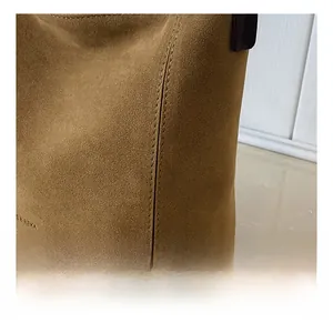 Detailed close-up of precise stitching and premium suede texture on a brown hobo bag