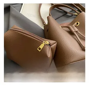 Detailed macro view of brown pebbled leather bucket bag with golden hardware accents