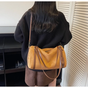 Brown vintage suede Boston bag shown on a model with adjustable leather shoulder strap
