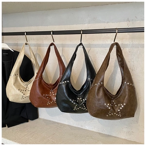 Detailed view of vintage star studded hobo bags in four colors hanging on a metal rack
