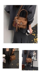 Detail of vintage brown suede handbag with metal clasp and playful bear charm