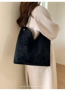 Nahaufnahme der minimalistischen schwarzen Wildleder-Tote-Bag mit Textur und Nieten