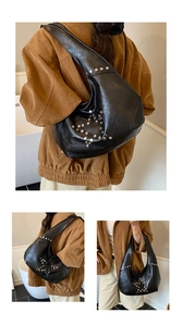 Detail of black leather hobo bag featuring silver star-shaped rivet studs and large capacity