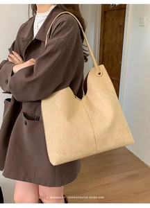 Detailaufnahme einer beigen Wildleder-Einkaufstasche mit elegantem V-Ausschnitt-Design