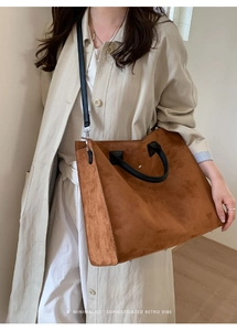 Dettaglio della grande borsa tote in pelle scamosciata marrone con tracolla nera retro