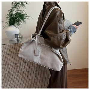 Lifestyle shot of large gray suede tote bag with minimalist shoulder strap on model