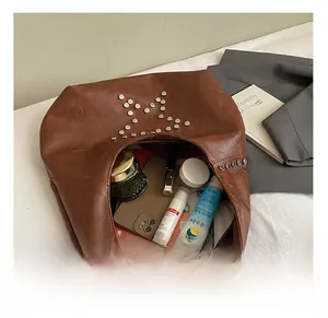 Detail view of large capacity brown rivet hobo bag with interior storage space