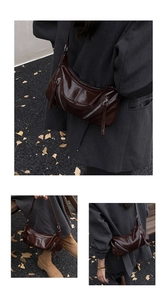Detail of dark brown glossy crescent bag with vintage texture and zipper accents