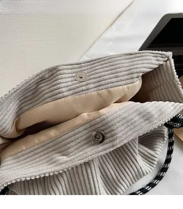 Close-up of light grey corduroy tote bag showing the magnetic snap closure and lining