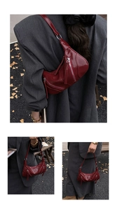 Detail of burgundy crescent bag featuring silver zippers and long tassels on leather