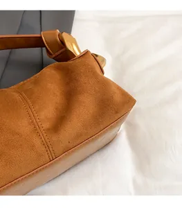 Detail of brown frosted leather shoulder bag with gold buckle and wide strap