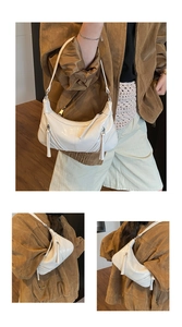 Detailed views of a white semi-circle leather shoulder bag with tassels and silver zippers