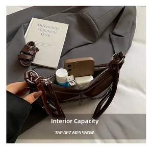 Interior view of glossy faux leather handbag showing capacity for phone and makeup