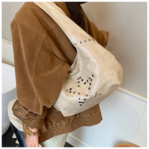 Detail of hobo shoulder bag featuring silver rivet star pattern and wide strap