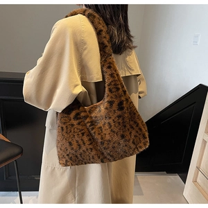 Détail d'un grand sac cabas en fausse fourrure léopard porté avec un trench élégant