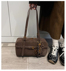 Brown vintage boston shoulder bag detail, stylish underarm bag with metal buckles and charms.