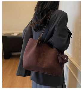 Detail of dark burgundy suede tote bag with knotted strap and matching coin purse