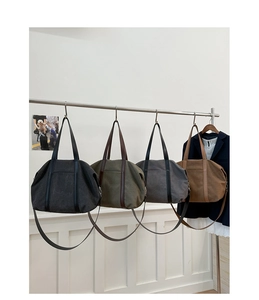 Detail of four canvas tote bags in black, green, grey, and brown with leather handles