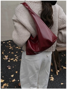 Detail view of the wine red glossy tote bag showing stitching and shiny texture