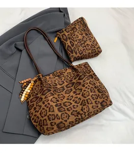 Dettaglio della borsa tote leopardata con ciondolo di perline e pochette coordinata