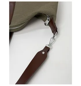 Detailed macro view of high-quality silver hardware on olive canvas tote bag