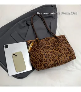 Confronto dettagliato delle dimensioni della borsa leopardata con telefono e tablet