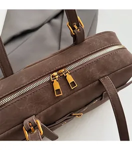 Detail shot of smooth bronze dual-zipper closure on brown retro Boston leather handbag