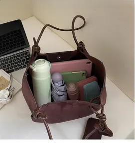 Interior view showing large capacity of the brown suede tote bag with daily essentials