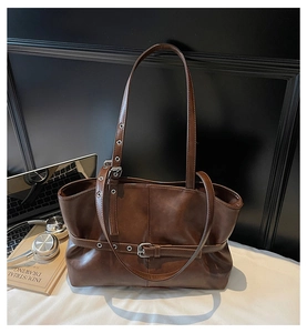 Détail du cabas vintage marron avec boucle de ceinture et œillets métalliques