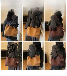 Detail view of large matte PU leather tote bag with long straps and mini charm pouch