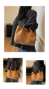 Close-up of brown suede tote bag with slim shoulder straps and a matching mini coin pouch