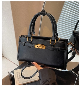 Détail du sac à main rectangulaire en cuir noir avec boucle dorée et bandoulière