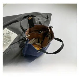 Top-down view of blue denim handbag interior capacity with phone and essentials