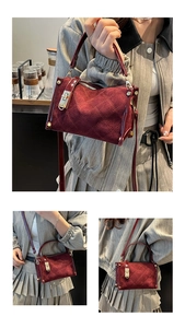 Detail of burgundy quilted bag with gold metal lock and adjustable shoulder strap