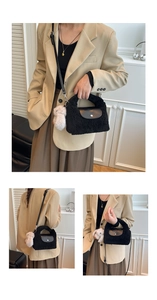 Detail of black plush handbag featuring leather flap and cute bear pendant charm